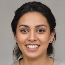 Joyful latino young-adult female with medium  brown hair and brown eyes