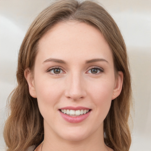 Joyful white young-adult female with medium  brown hair and green eyes