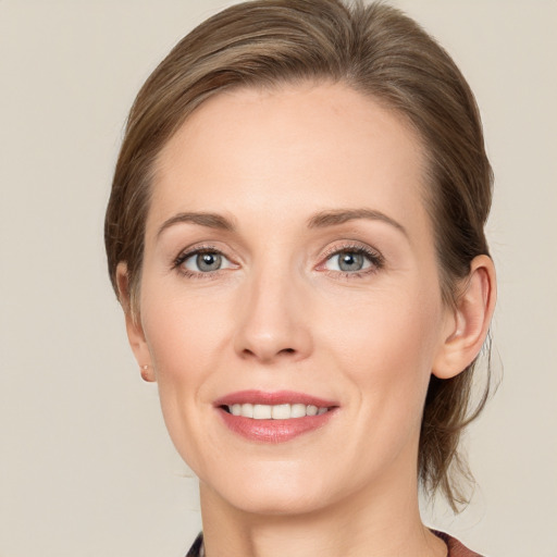 Joyful white adult female with medium  brown hair and grey eyes