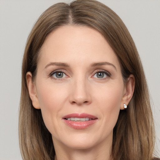 Joyful white adult female with long  brown hair and grey eyes