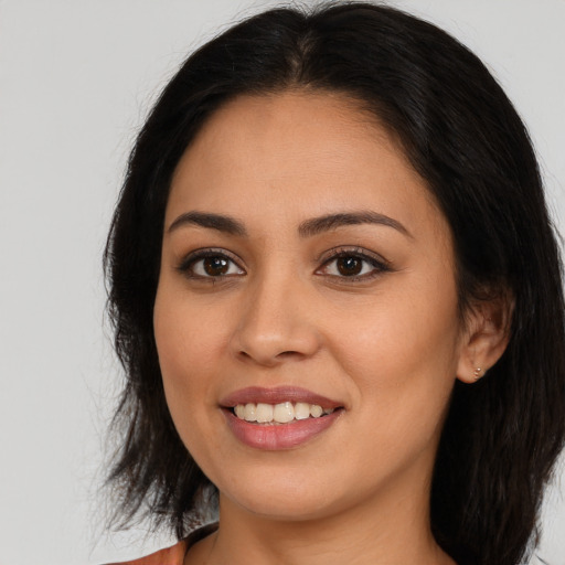 Joyful latino young-adult female with medium  brown hair and brown eyes