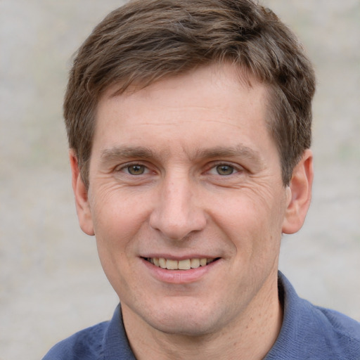 Joyful white adult male with short  brown hair and grey eyes