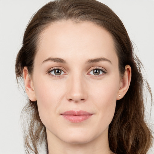 Joyful white young-adult female with long  brown hair and blue eyes