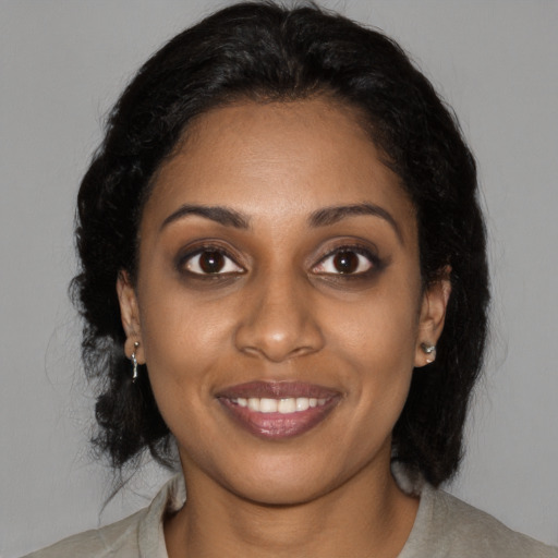 Joyful black young-adult female with long  brown hair and brown eyes