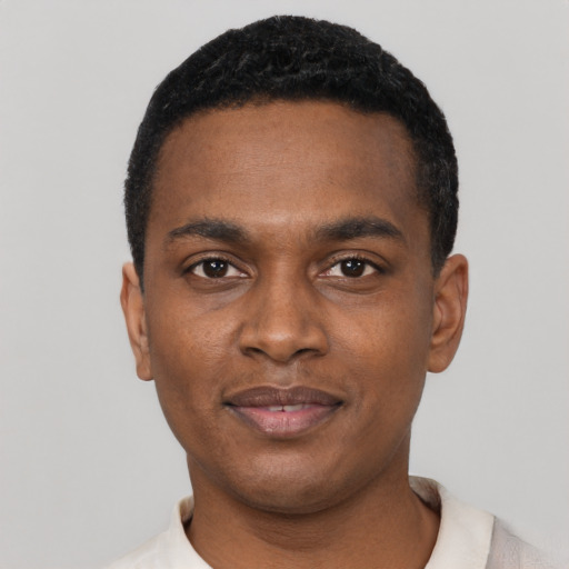 Joyful black young-adult male with short  black hair and brown eyes