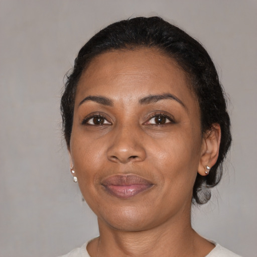 Joyful black adult female with medium  brown hair and brown eyes