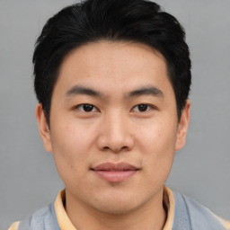 Joyful asian young-adult male with short  black hair and brown eyes