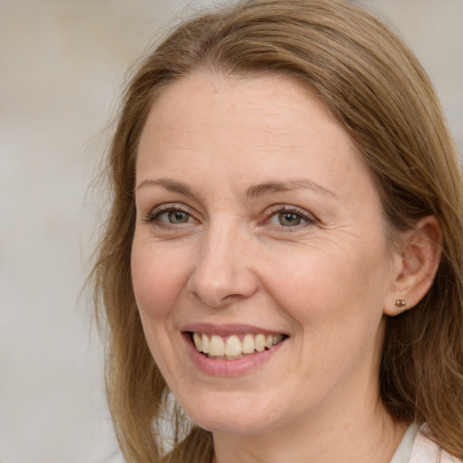 Joyful white adult female with medium  brown hair and blue eyes