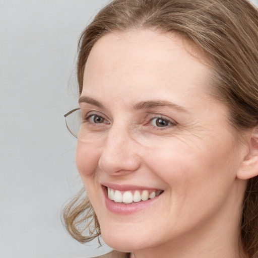 Joyful white young-adult female with long  brown hair and blue eyes