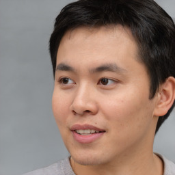 Joyful asian young-adult male with short  brown hair and brown eyes