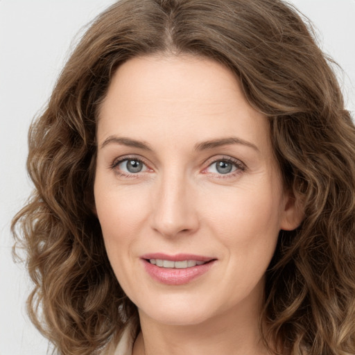 Joyful white adult female with long  brown hair and green eyes