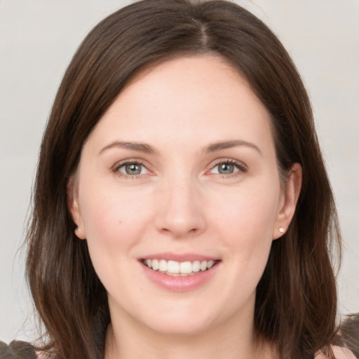 Joyful white young-adult female with long  brown hair and grey eyes