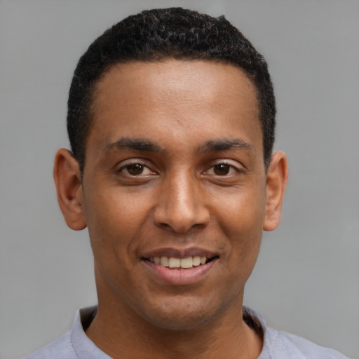 Joyful latino young-adult male with short  brown hair and brown eyes