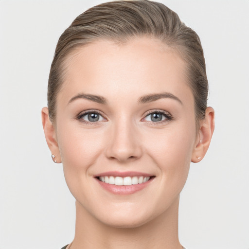 Joyful white young-adult female with short  brown hair and grey eyes