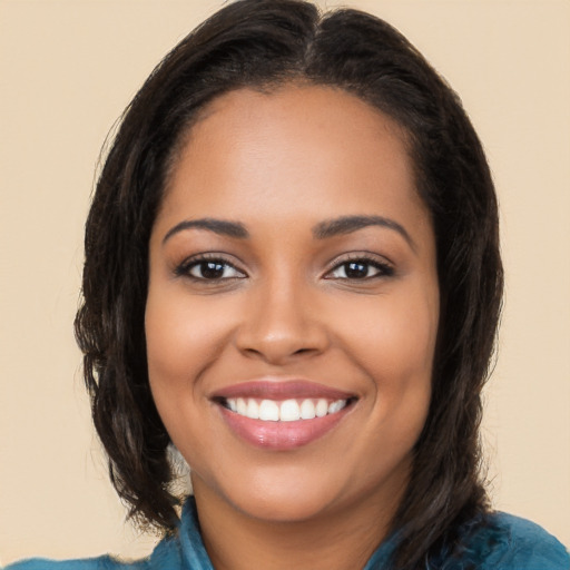 Joyful latino young-adult female with long  brown hair and brown eyes