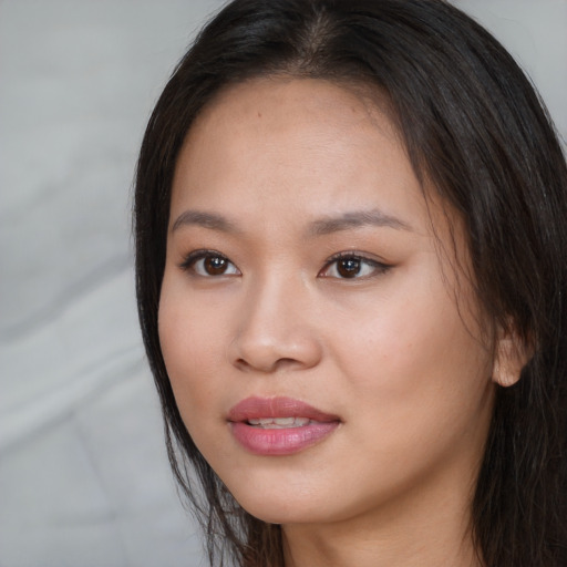 Joyful asian young-adult female with long  brown hair and brown eyes