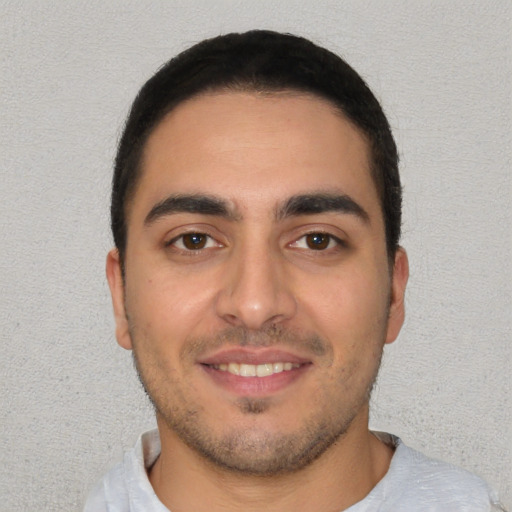 Joyful white young-adult male with short  black hair and brown eyes