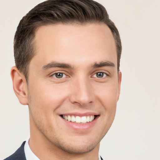 Joyful white young-adult male with short  brown hair and brown eyes