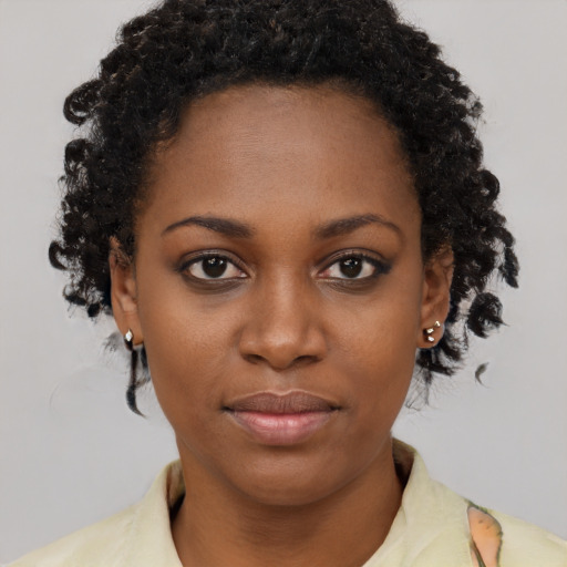Joyful black young-adult female with short  brown hair and brown eyes