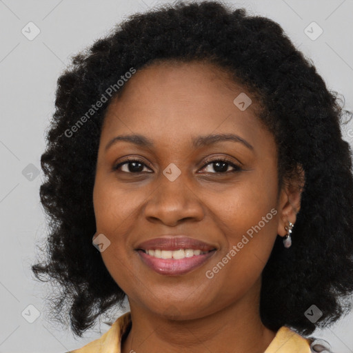 Joyful black young-adult female with long  brown hair and brown eyes