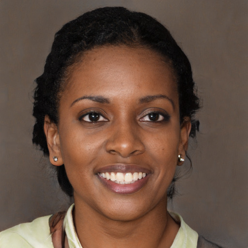 Joyful black young-adult female with long  brown hair and brown eyes