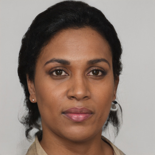 Joyful black young-adult female with short  black hair and brown eyes