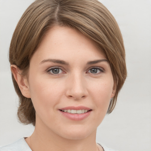 Joyful white young-adult female with medium  brown hair and grey eyes