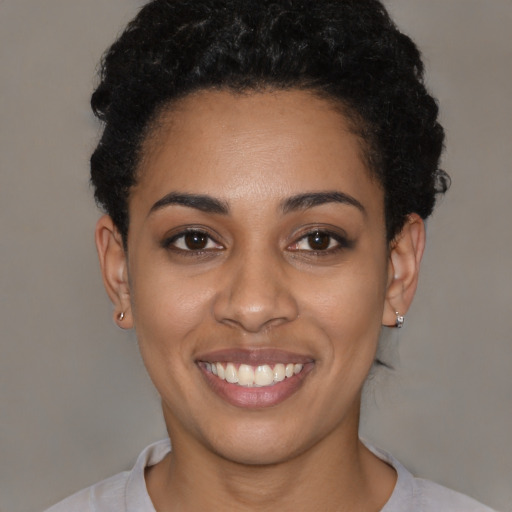 Joyful latino young-adult female with short  black hair and brown eyes