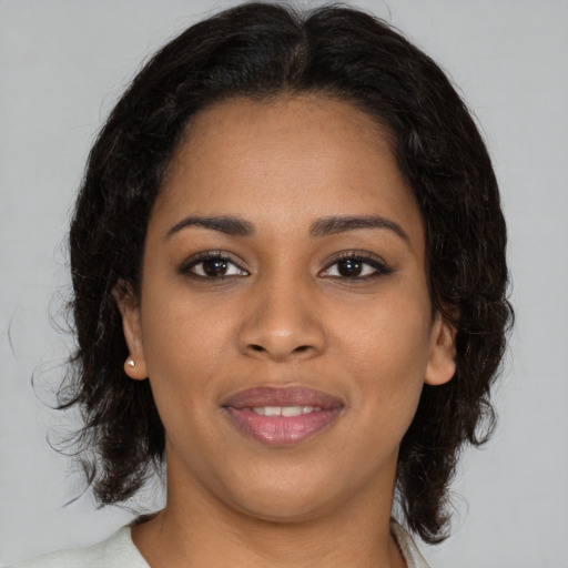 Joyful black young-adult female with medium  brown hair and brown eyes