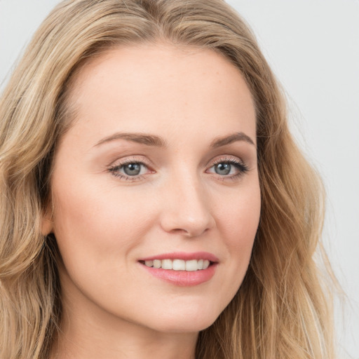 Joyful white young-adult female with long  brown hair and blue eyes