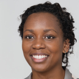 Joyful black young-adult female with long  brown hair and brown eyes