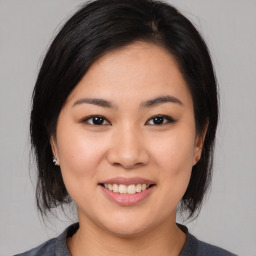 Joyful asian young-adult female with medium  black hair and brown eyes