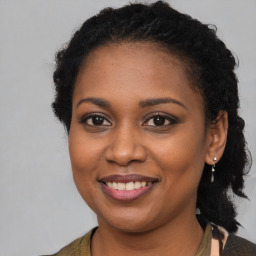 Joyful black young-adult female with long  brown hair and brown eyes