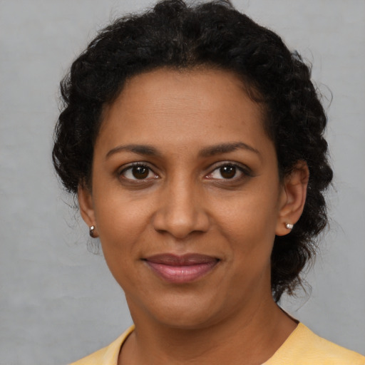 Joyful black young-adult female with short  brown hair and brown eyes