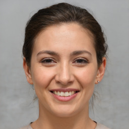 Joyful white young-adult female with medium  brown hair and brown eyes