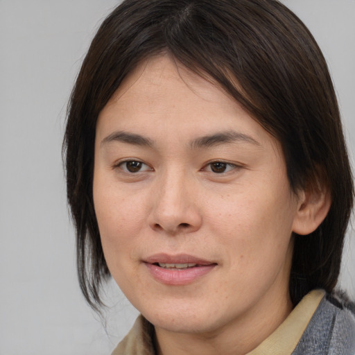 Joyful asian young-adult female with medium  brown hair and brown eyes