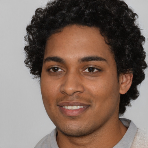 Joyful black young-adult male with short  black hair and brown eyes