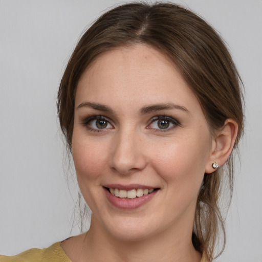 Joyful white young-adult female with medium  brown hair and grey eyes