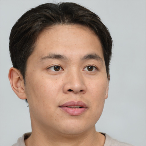 Joyful asian adult male with short  brown hair and brown eyes