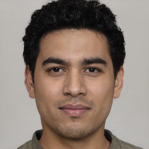 Joyful latino young-adult male with short  black hair and brown eyes