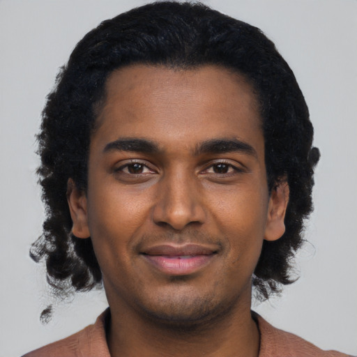 Joyful black young-adult male with short  black hair and brown eyes