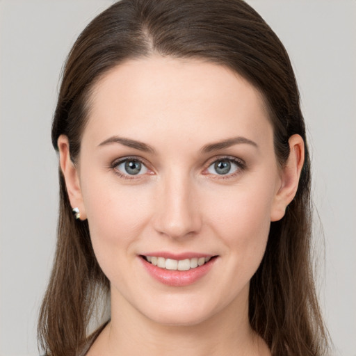 Joyful white young-adult female with long  brown hair and grey eyes