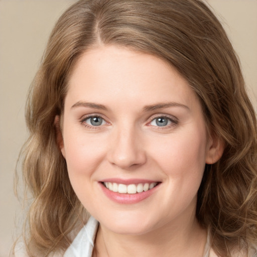 Joyful white young-adult female with medium  brown hair and grey eyes