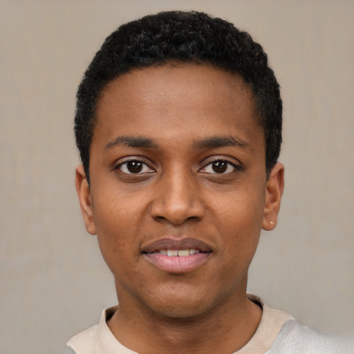 Joyful black young-adult male with short  black hair and brown eyes