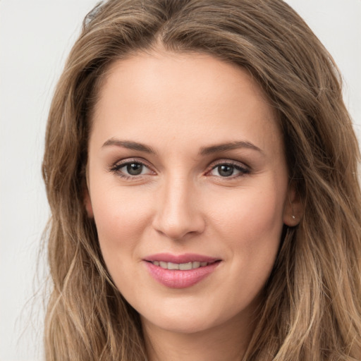 Joyful white young-adult female with long  brown hair and green eyes