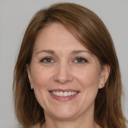 Joyful white adult female with medium  brown hair and grey eyes