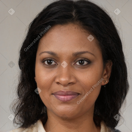 Joyful black adult female with long  brown hair and brown eyes