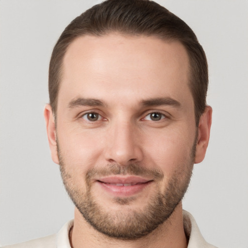 Joyful white young-adult male with short  brown hair and grey eyes