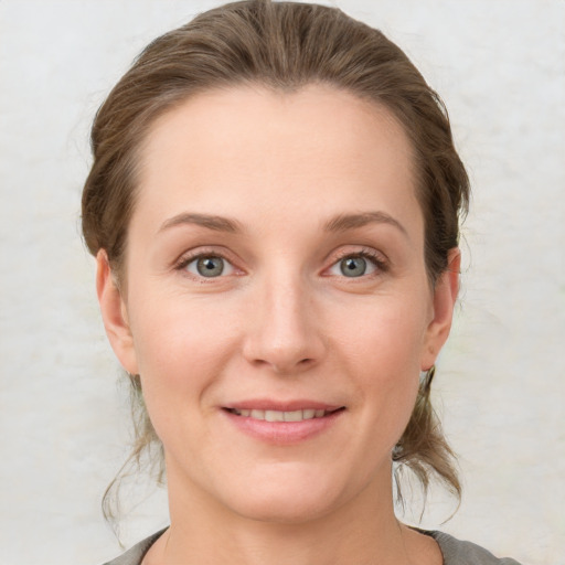 Joyful white young-adult female with medium  brown hair and grey eyes