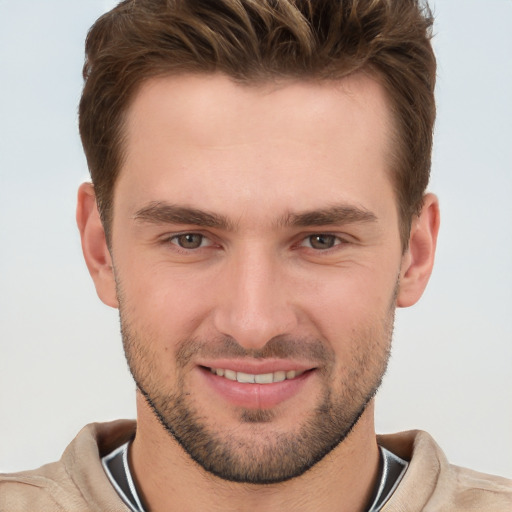 Joyful white young-adult male with short  brown hair and grey eyes